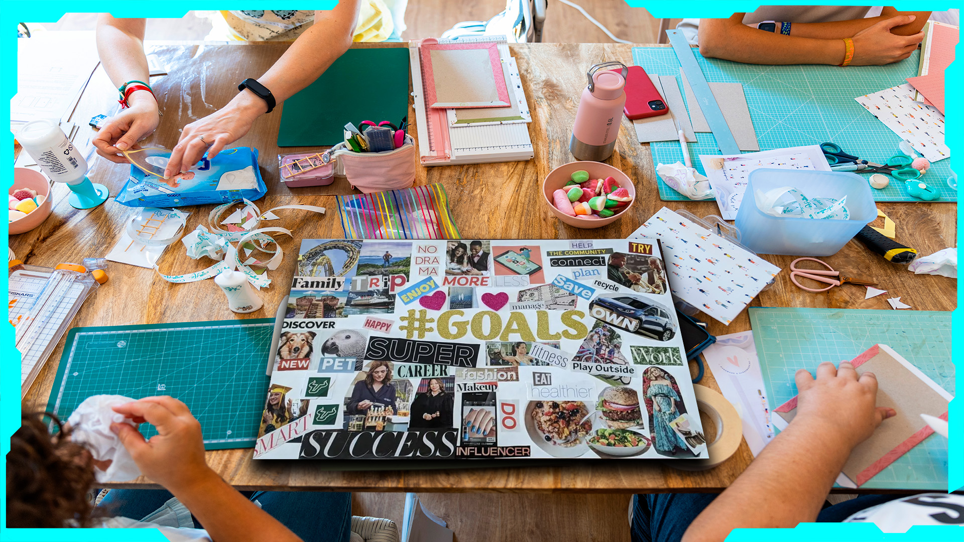 A diverse group of people sitting around a large table, creating vision boards with magazines, scissors, glue, and colorful markers.